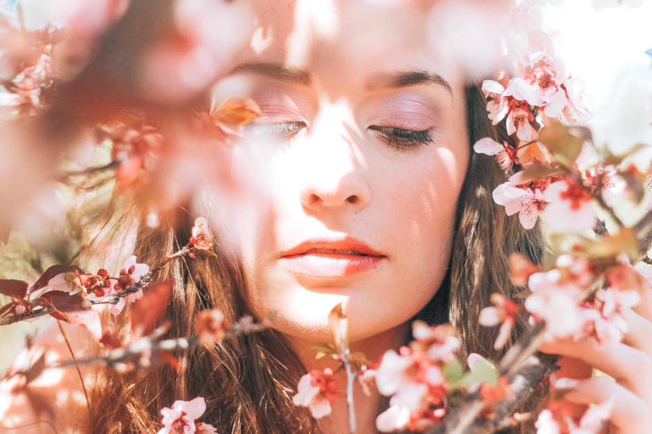 Woman Standing Near a Tree Branch Full of Flowers